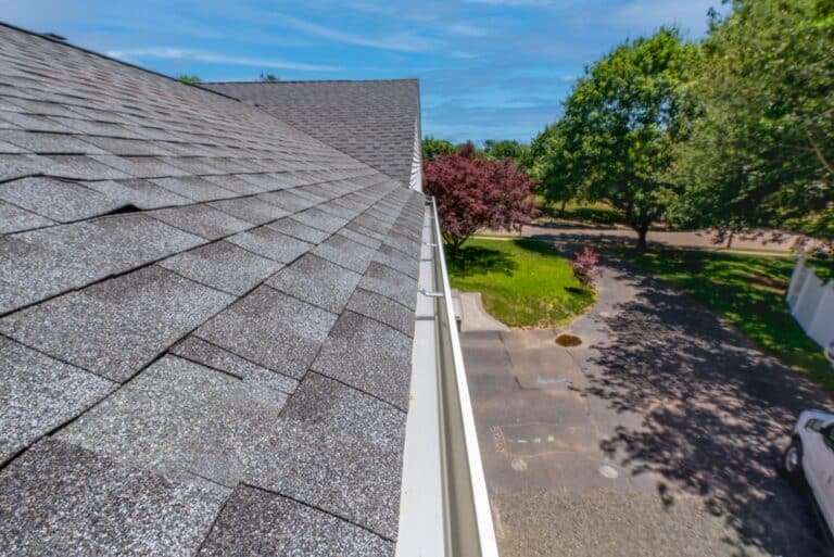 Cleaned gutters early spring that had not been cleaned last fall. Aluminum gutters that have been cleaned and flushed with water so that they gleam. Looking the length of the gutter home maintenance